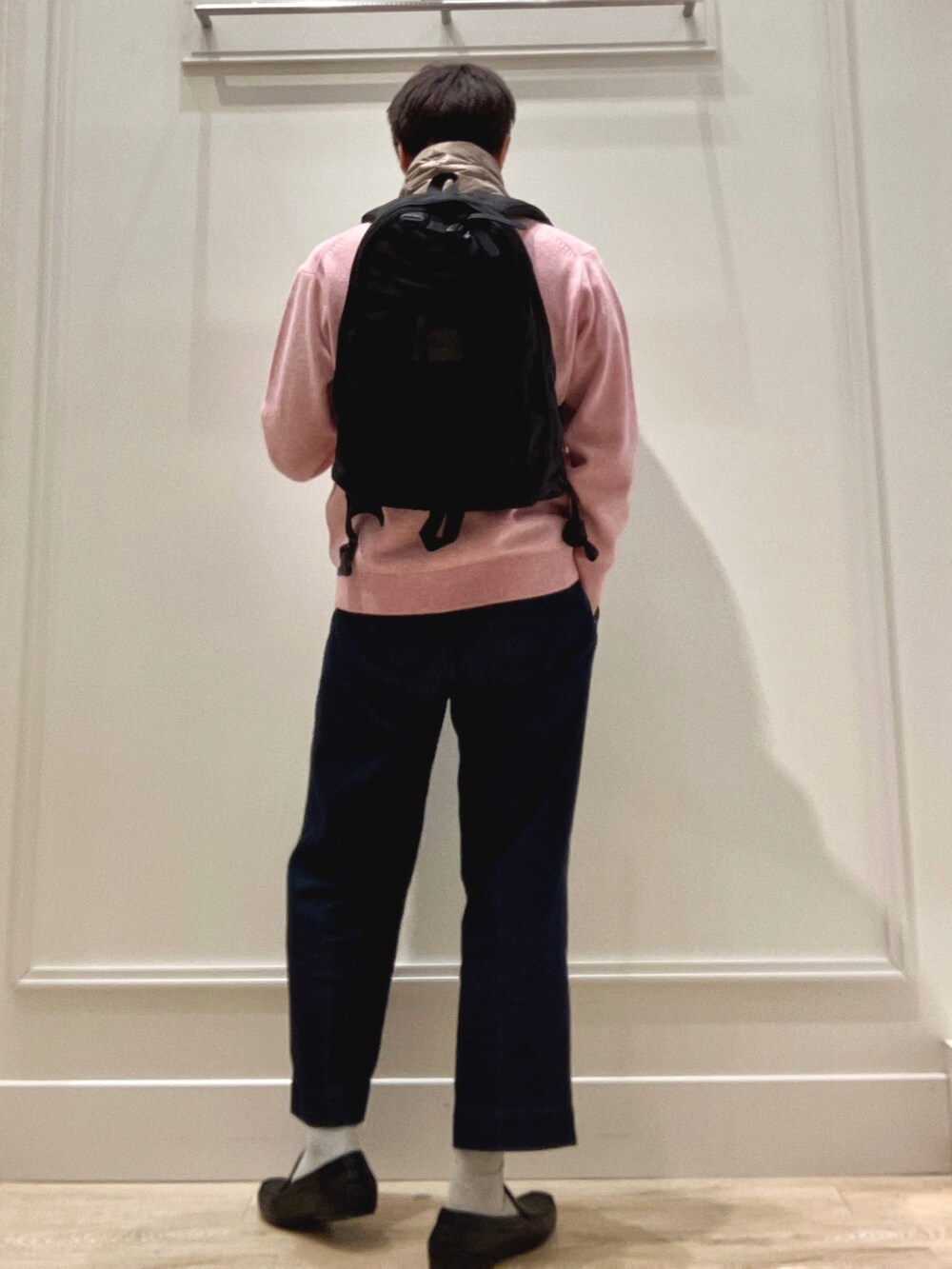 ピンク系のニット/セーター、ブラック系のバックパック/リュック、グリーン系のマフラーを着用したメンズの冬コーディネートの5枚目の写真