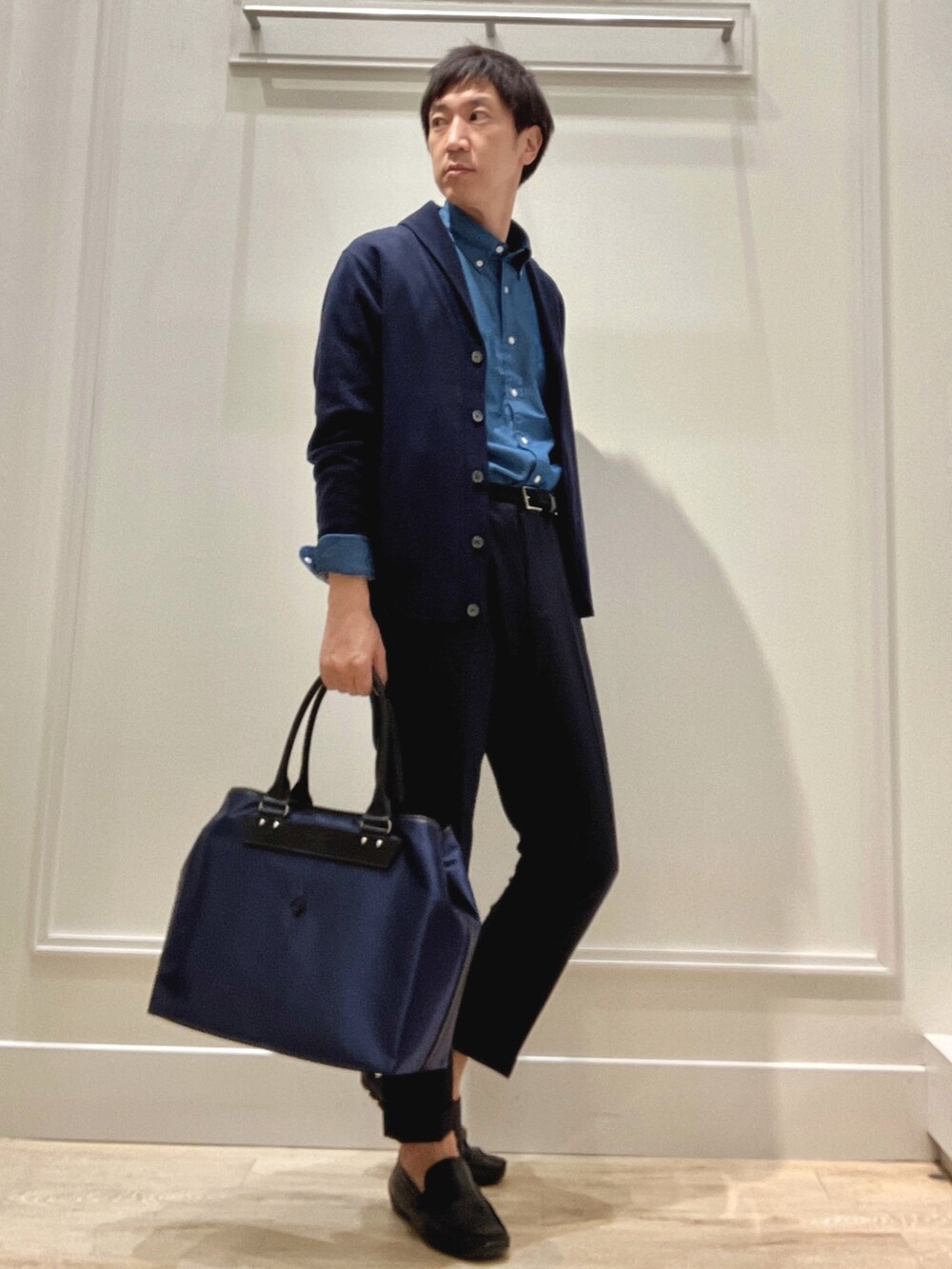 ブルー系のカーディガン/ボレロ、ブルー系のシャツ/ブラウス、ブラック系のトートバッグを着用したメンズの秋コーディネートの5枚目の写真