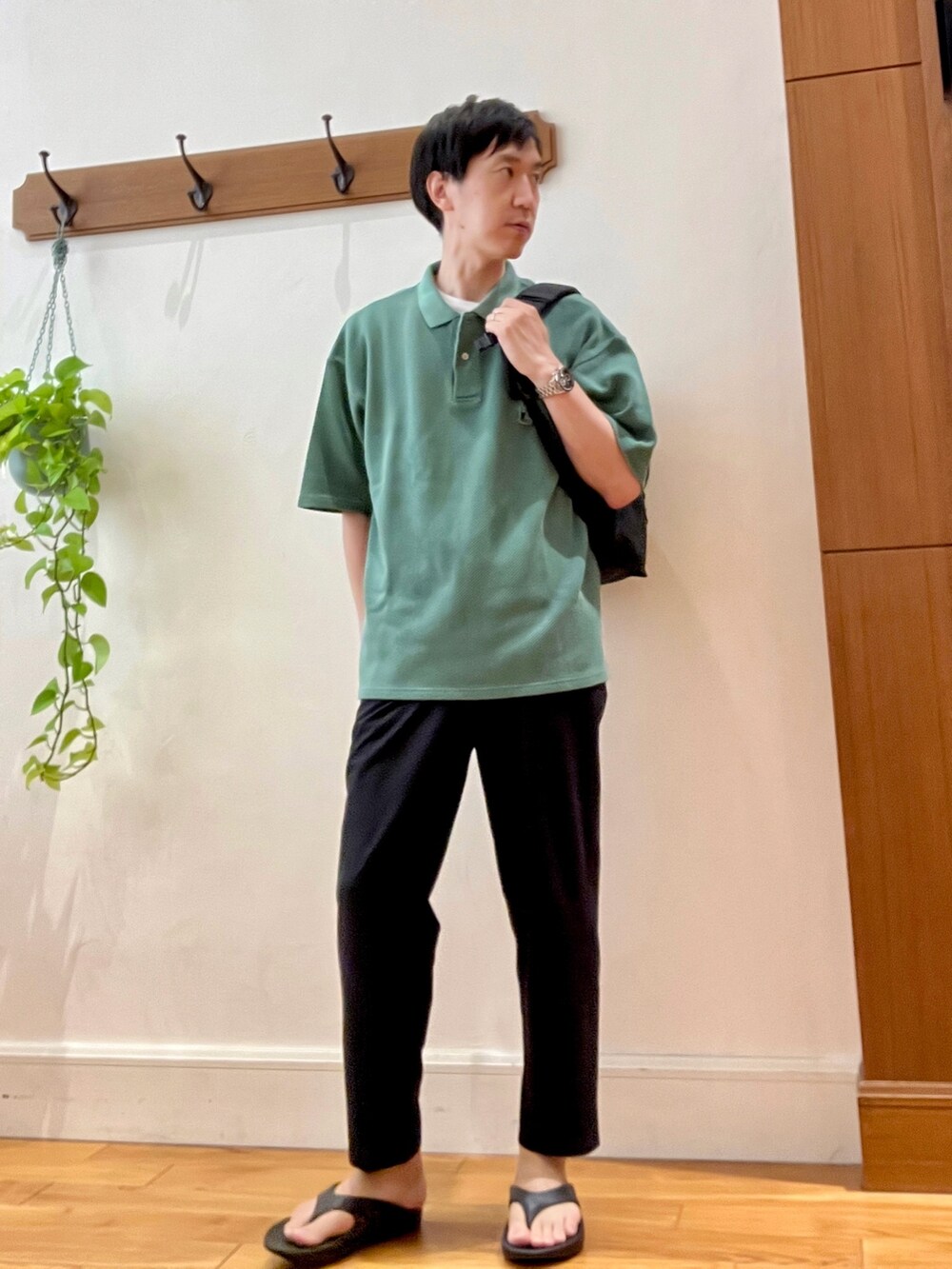 グレー系のその他パンツ、ブラック系のサンダル、グリーン系のポロシャツを着用したメンズの春コーディネートの2枚目の写真