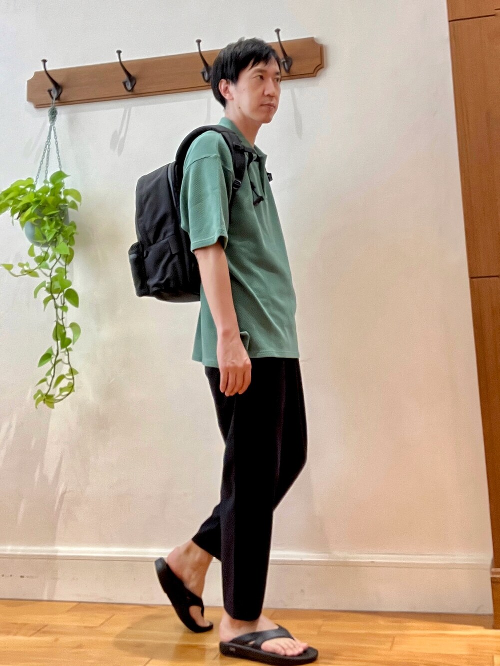 グレー系のその他パンツ、ブラック系のサンダル、グリーン系のポロシャツを着用したメンズの春コーディネートの6枚目の写真