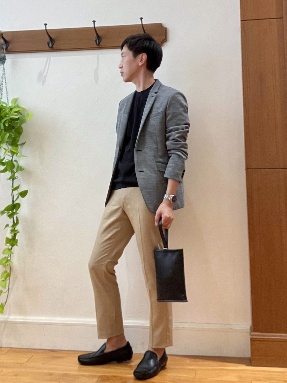 グレー系のテーラードジャケット、ブラック系のTシャツ/カットソー、ブラック系のハンドバッグを着用したメンズの秋コーディネートの3枚目の写真