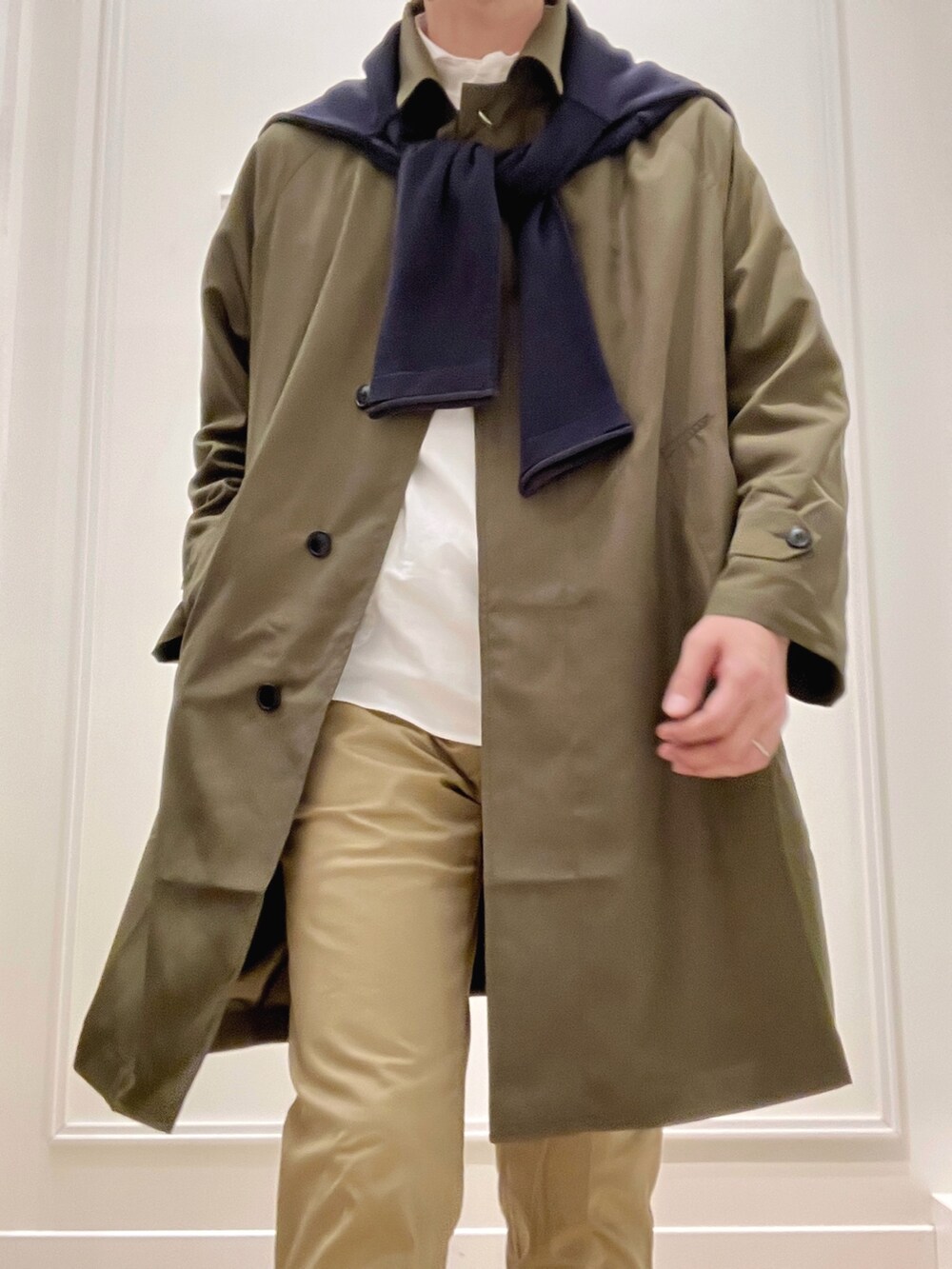 グリーン系のステンカラーコート、ベージュ系のチノパンツ、ブルー系のカーディガン/ボレロを着用したメンズの冬コーディネートの8枚目の写真