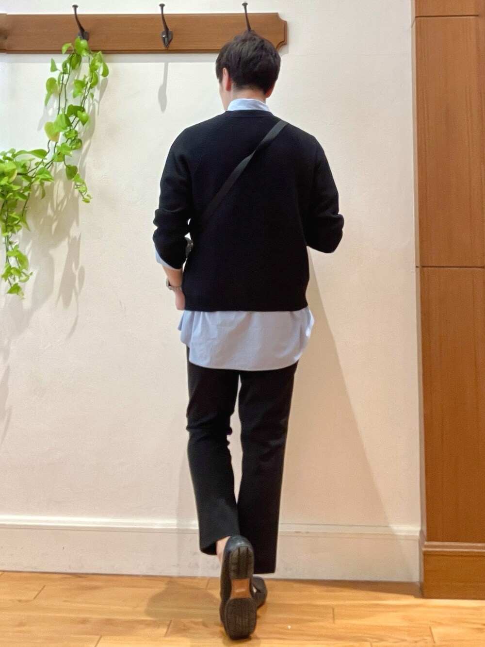 ブラック系のニット/セーター、グレー系のショルダーバッグ、ブルー系のシャツ/ブラウスを着用したメンズの春コーディネートの5枚目の写真