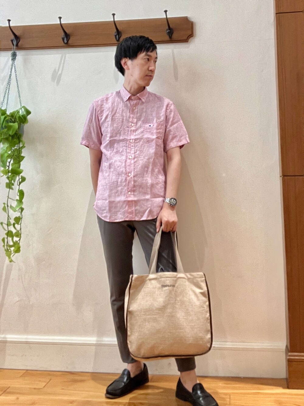 レッド系のシャツ/ブラウス、グレー系のその他パンツ、ベージュ系のトートバッグを着用したメンズの春コーディネートの3枚目の写真
