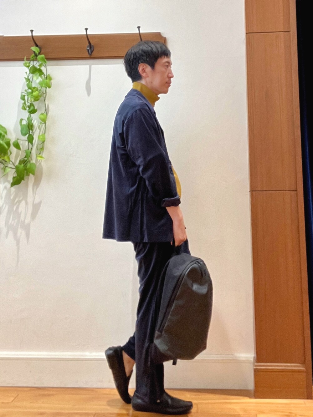 ブルー系のシャツ/ブラウス、イエロー系のニット/セーター、グレー系のバックパック/リュックを着用したメンズの秋コーディネートの6枚目の写真