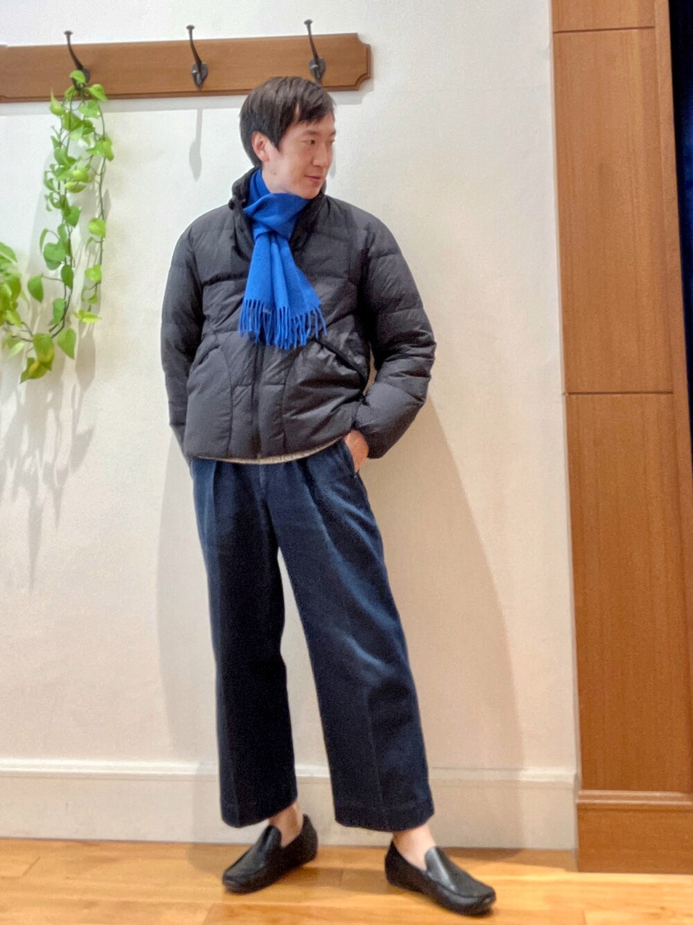 グリーン系のダウンジャケット/コート、ブルー系のニット/セーター、ブルー系のマフラーを着用したメンズの秋コーディネートの8枚目の写真