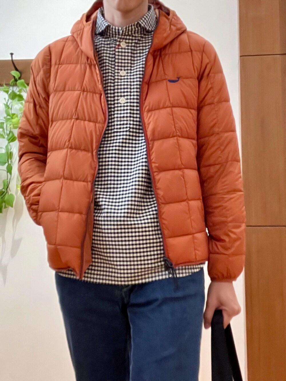 ブラック系のトートバッグ、ブルー系のデニムパンツ、オレンジ系のダウンジャケット/コートを着用したメンズの秋コーディネートの7枚目の写真