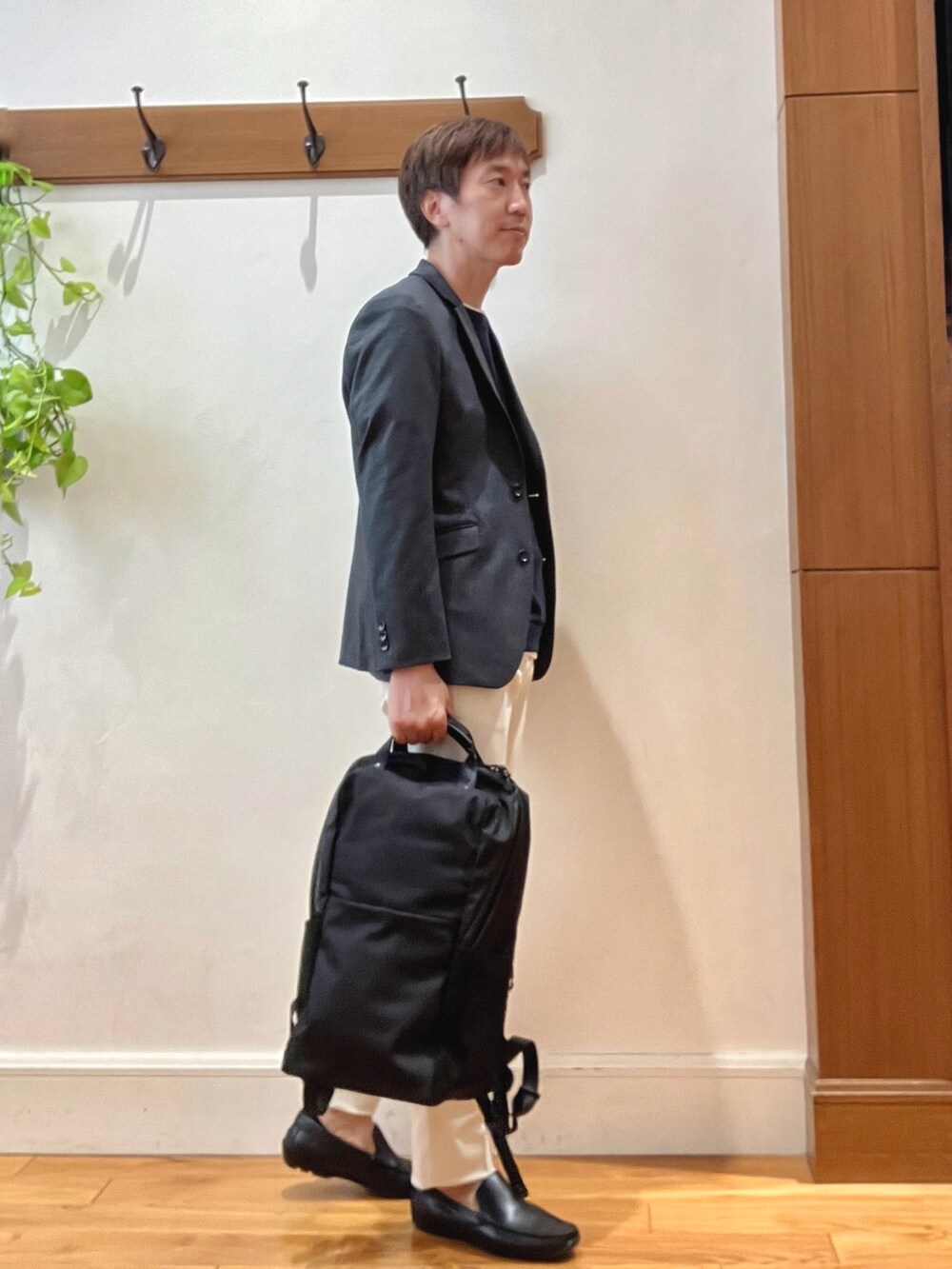 ホワイト系のチノパンツ、ブラック系のバックパック/リュック、ブルー系のテーラードジャケットを着用したメンズの秋コーディネートの6枚目の写真