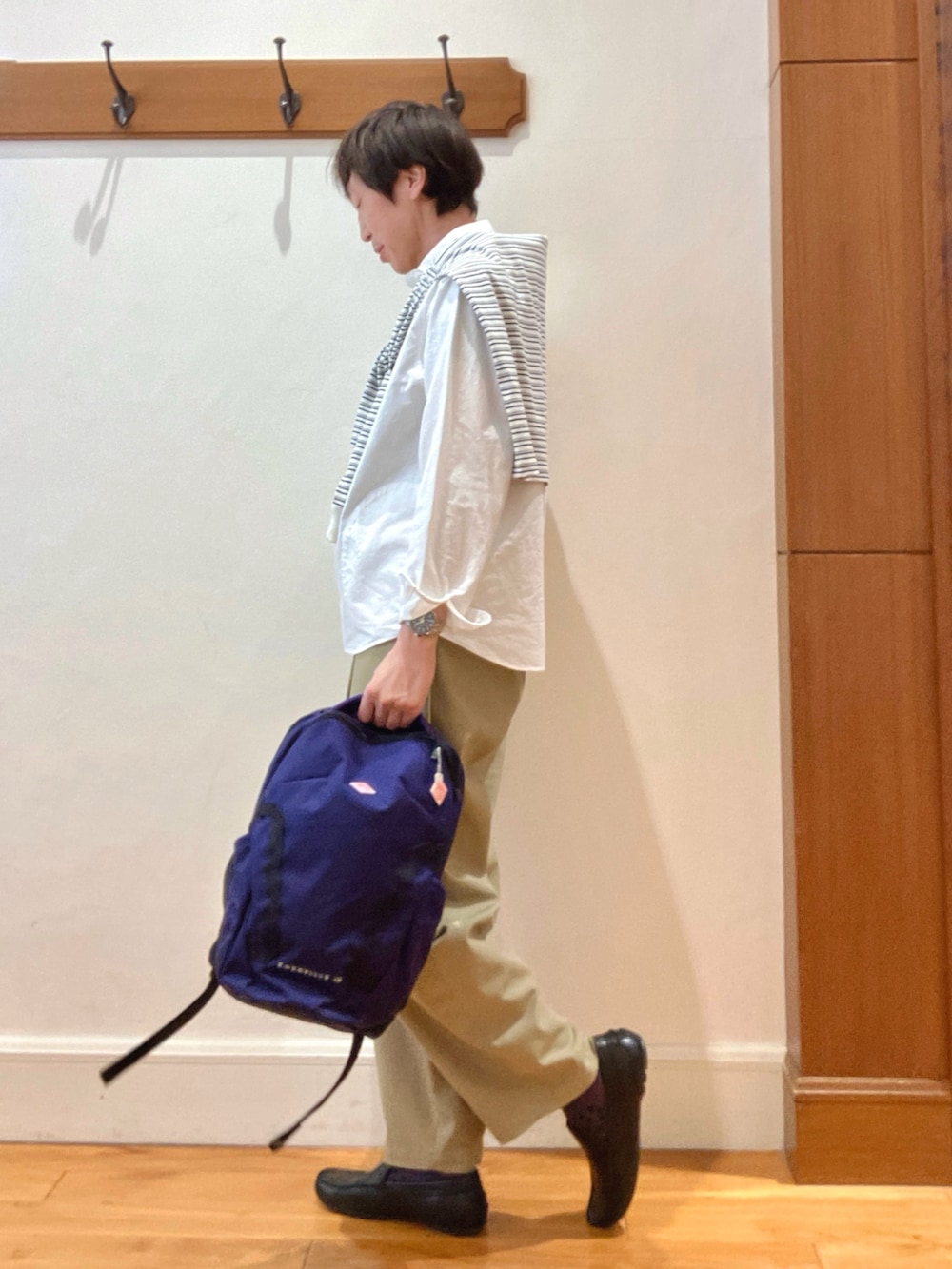 ホワイト系のシャツ/ブラウス、ホワイト系のTシャツ/カットソー、ブルー系のバックパック/リュックを着用したメンズの春コーディネートの3枚目の写真