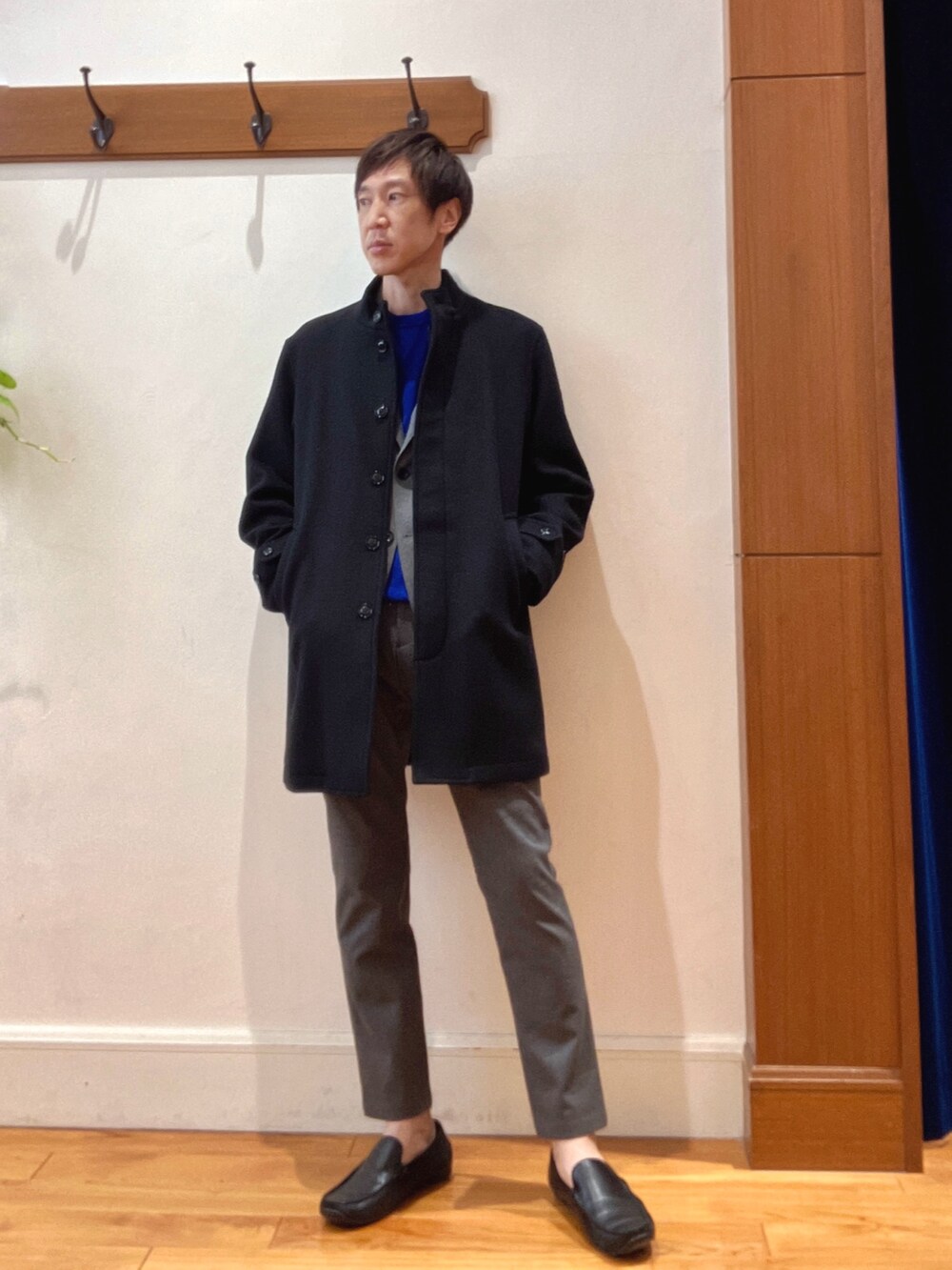 ブラック系のその他アウター、ブルー系のニット/セーター、グレー系のテーラードジャケットを着用したメンズの秋コーディネートの2枚目の写真