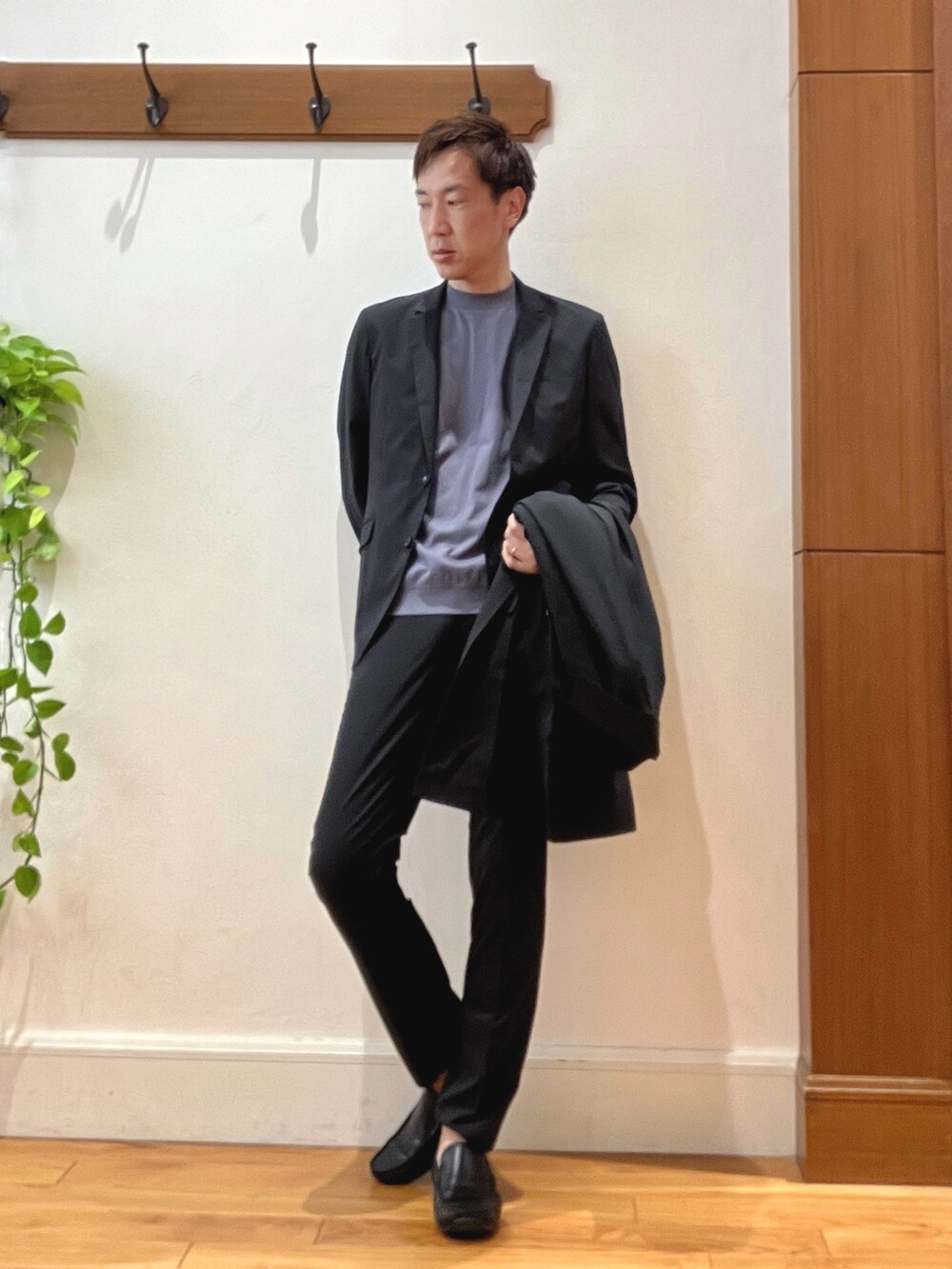 ブラック系のステンカラーコート、グレー系のTシャツ/カットソー、ブラック系のその他パンツを着用したメンズの夏コーディネートの7枚目の写真