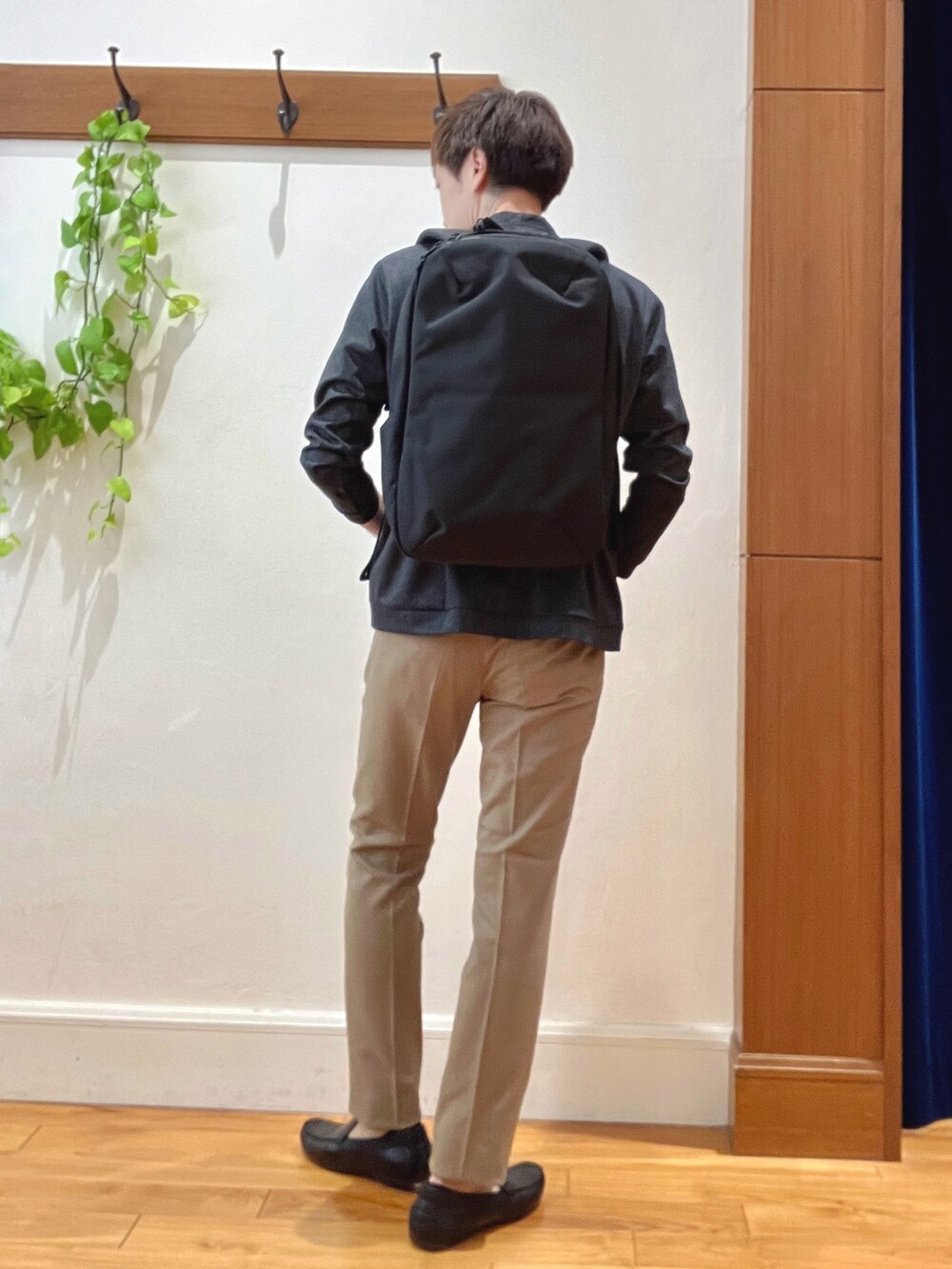 ブルー系のカーディガン/ボレロ、ホワイト系のTシャツ/カットソー、ブラック系のバックパック/リュックを着用したメンズの秋コーディネートの5枚目の写真