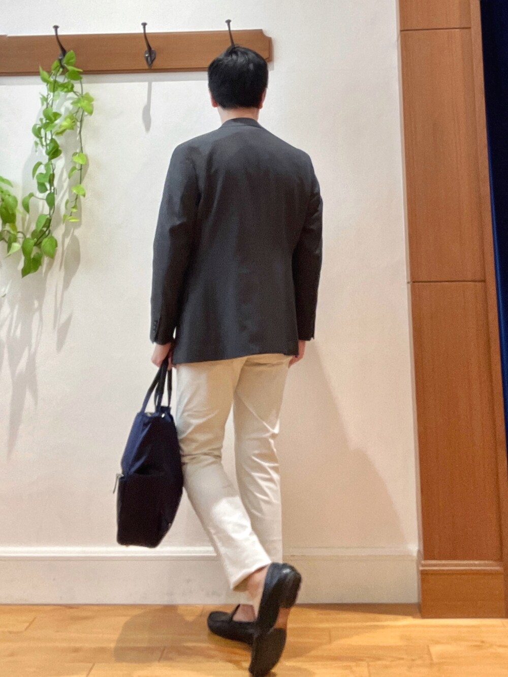 パープル系のニット/セーター、ホワイト系のチノパンツ、ブルー系のトートバッグを着用したメンズの秋コーディネートの4枚目の写真