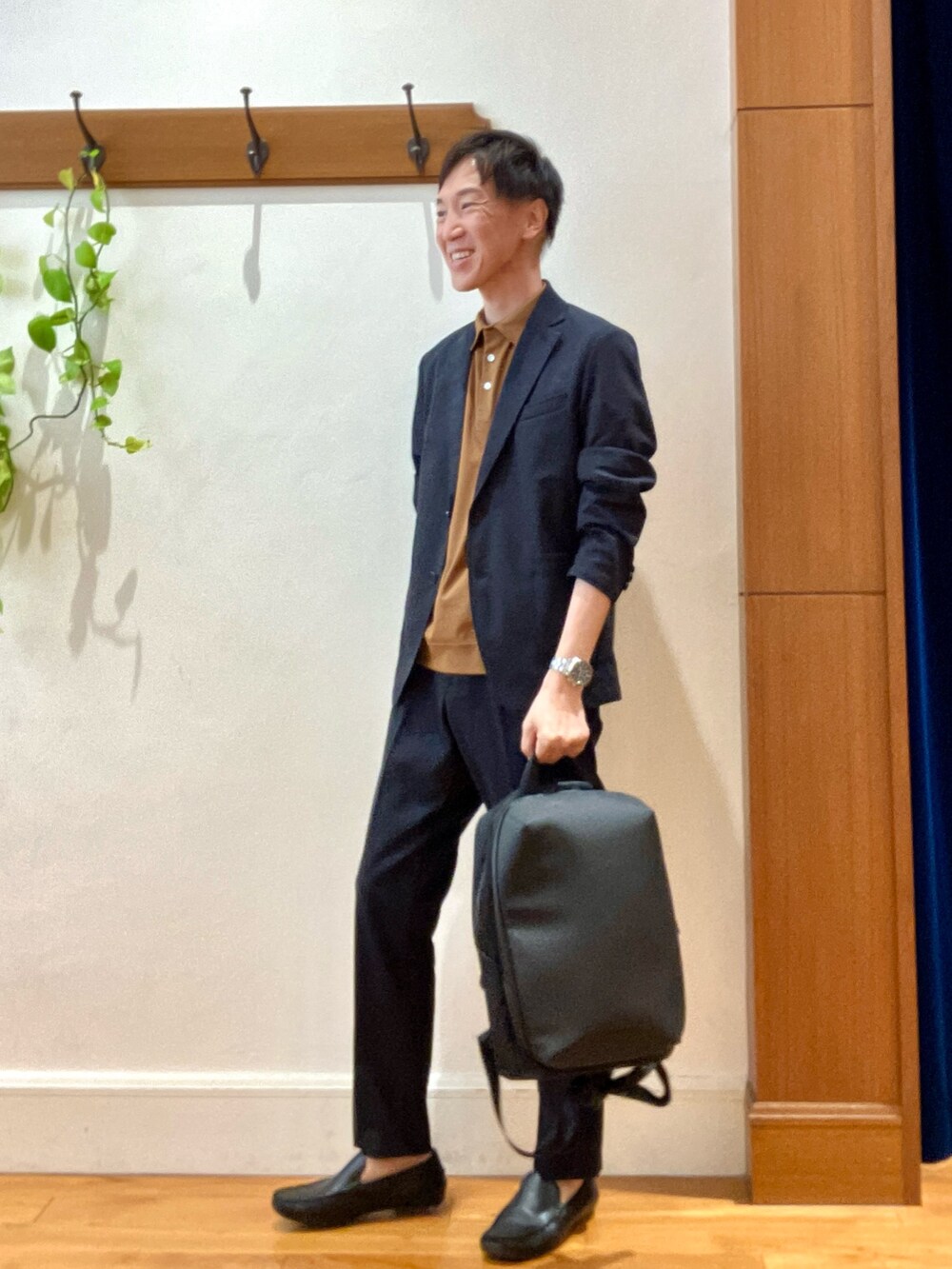 ブラック系のテーラードジャケット、ブラック系のその他パンツ、ブラック系のバックパック/リュックを着用したメンズの夏コーディネートの2枚目の写真