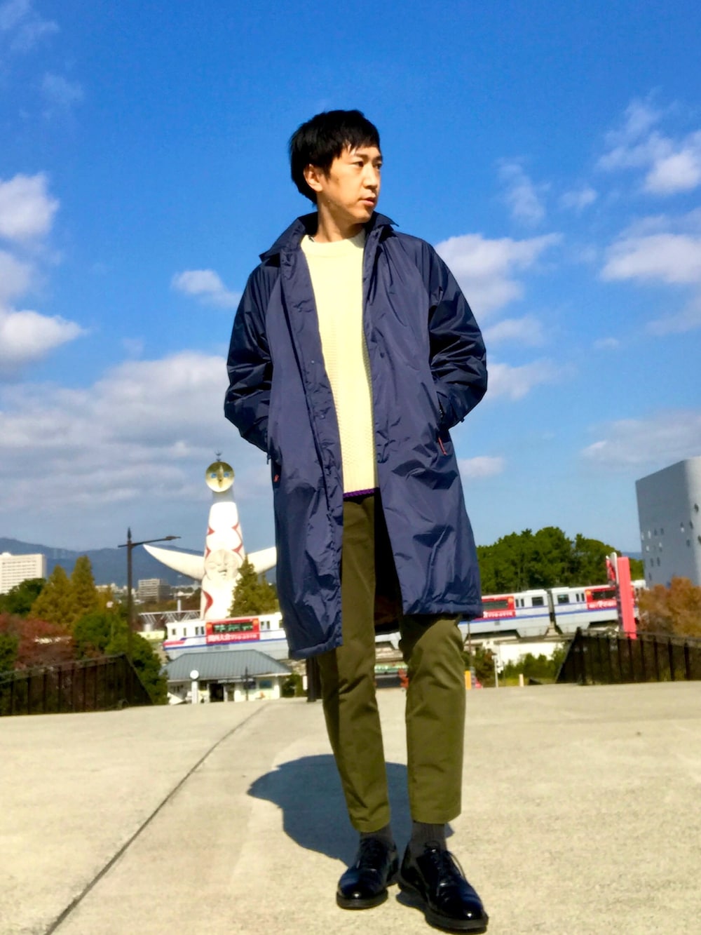 ブルー系のダウンジャケット/コート、ホワイト系のニット/セーター、グリーン系のチノパンツを着用したメンズの冬コーディネートの3枚目の写真