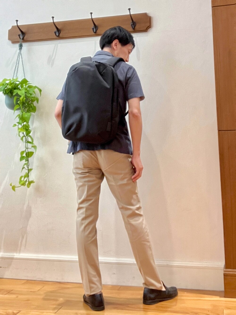 グレー系のポロシャツ、ブラック系のバックパック/リュック、ベージュ系のその他パンツを着用したメンズの春コーディネートの6枚目の写真