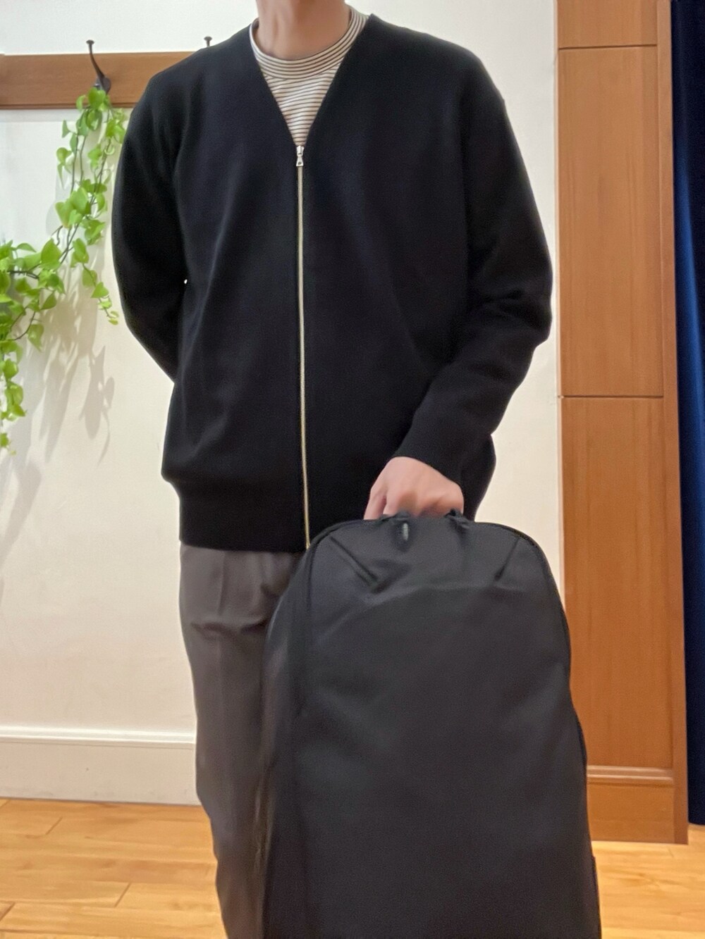 ブラック系のカーディガン/ボレロ、ホワイト系のTシャツ/カットソー、ブラック系のバックパック/リュックを着用したメンズの冬コーディネートの9枚目の写真