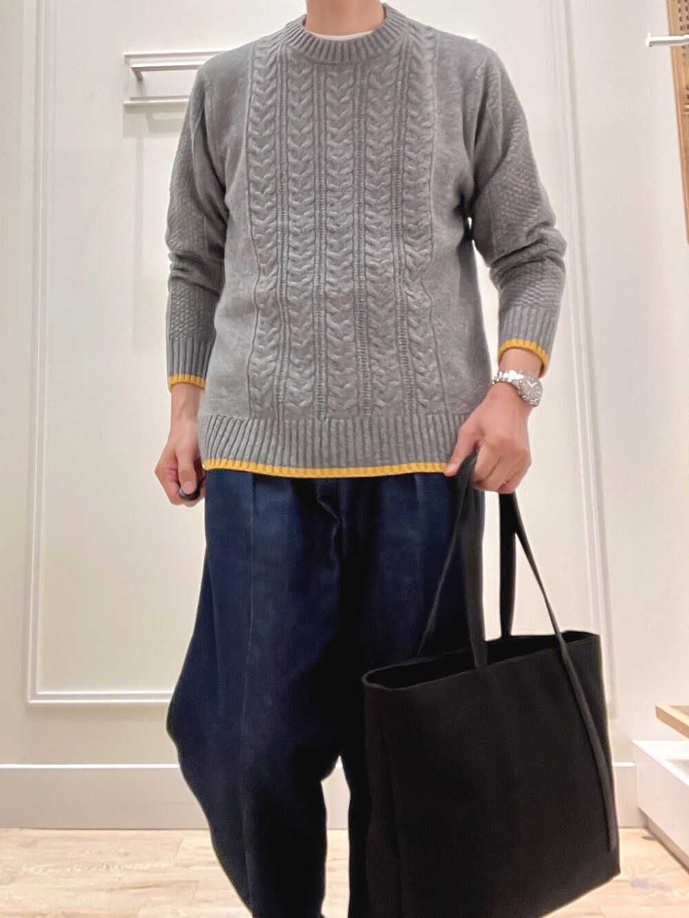 グレー系のニット/セーター、グレー系のトートバッグを着用したメンズの秋コーディネートの7枚目の写真