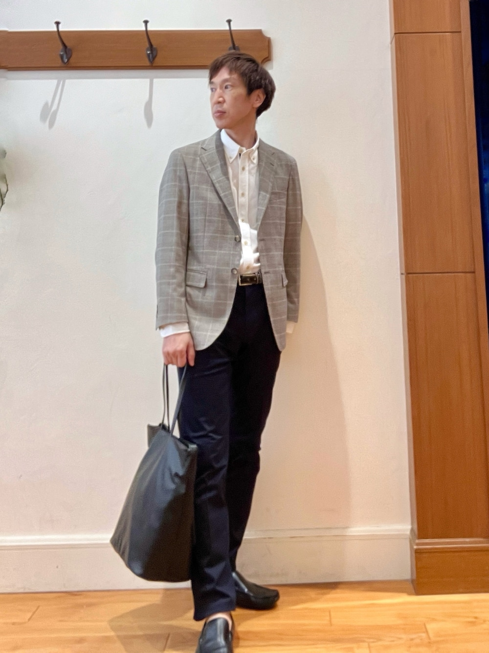 ブラック系のトートバッグ、ブルー系のチノパンツ、ブラウン系のテーラードジャケットを着用したメンズの夏コーディネートの7枚目の写真