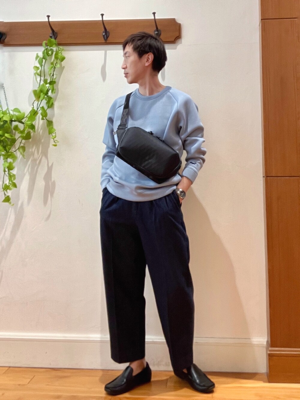 ブルー系のデニムパンツ、ブルー系のスウェット、ブラック系のショルダーバッグを着用したメンズの冬コーディネートの2枚目の写真