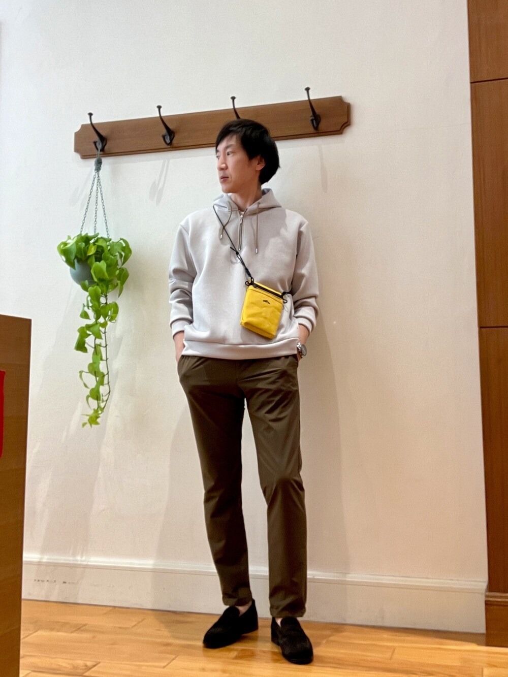 ベージュ系のパーカー、イエロー系のショルダーバッグ、ブラウン系のその他パンツを着用したメンズの冬コーディネートの3枚目の写真