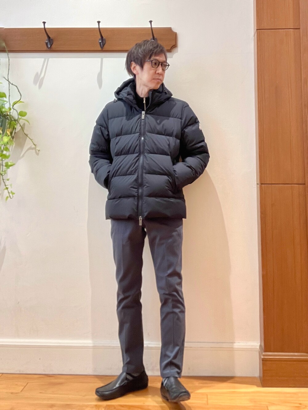 グレー系のチノパンツ、ブラック系のニット/セーター、ブラック系のダウンジャケット/コートを着用したメンズの冬コーディネートの8枚目の写真