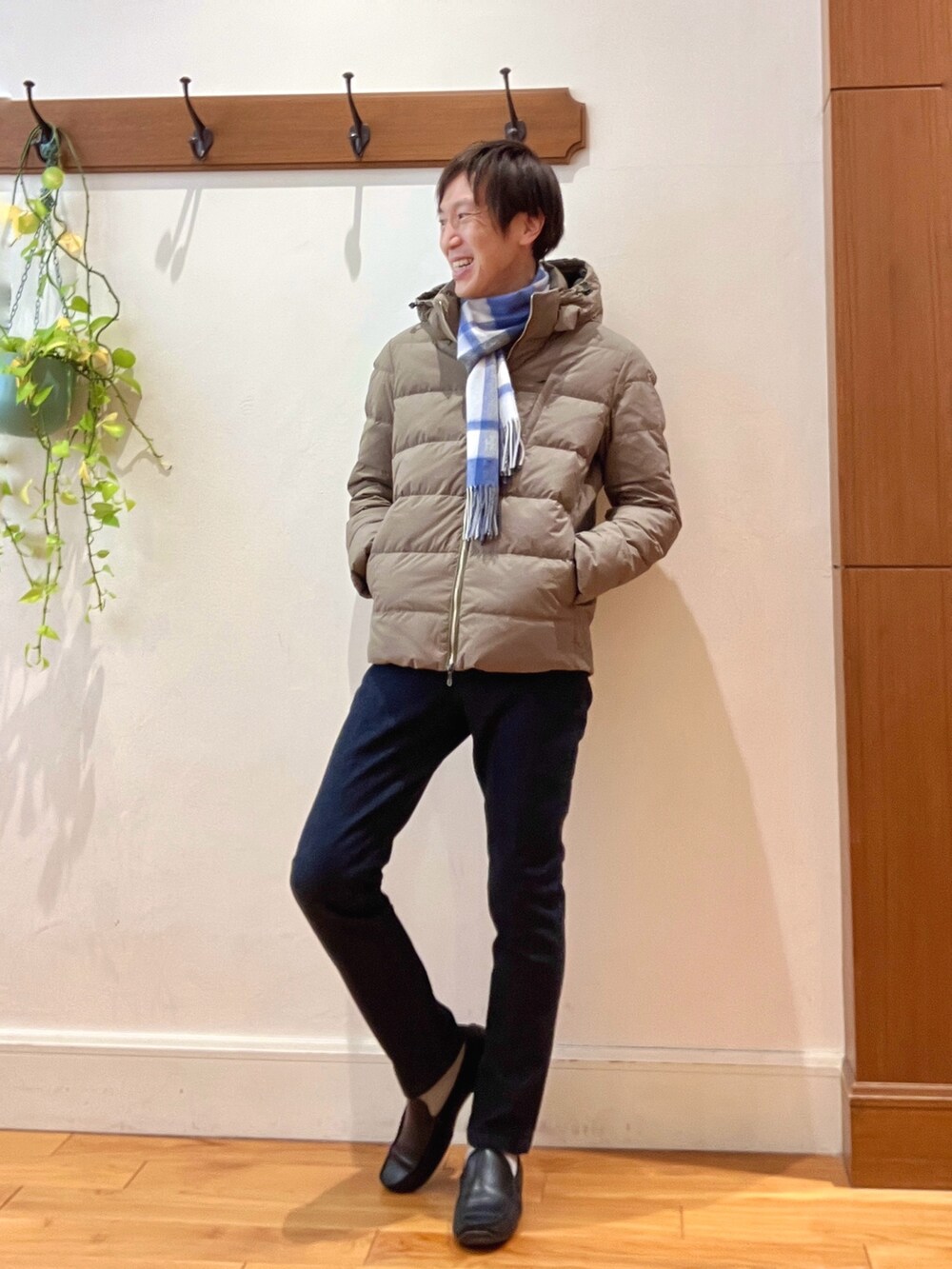 グリーン系のダウンジャケット/コート、ブルー系のニット/セーター、ブルー系のデニムパンツを着用したメンズの冬コーディネートの8枚目の写真