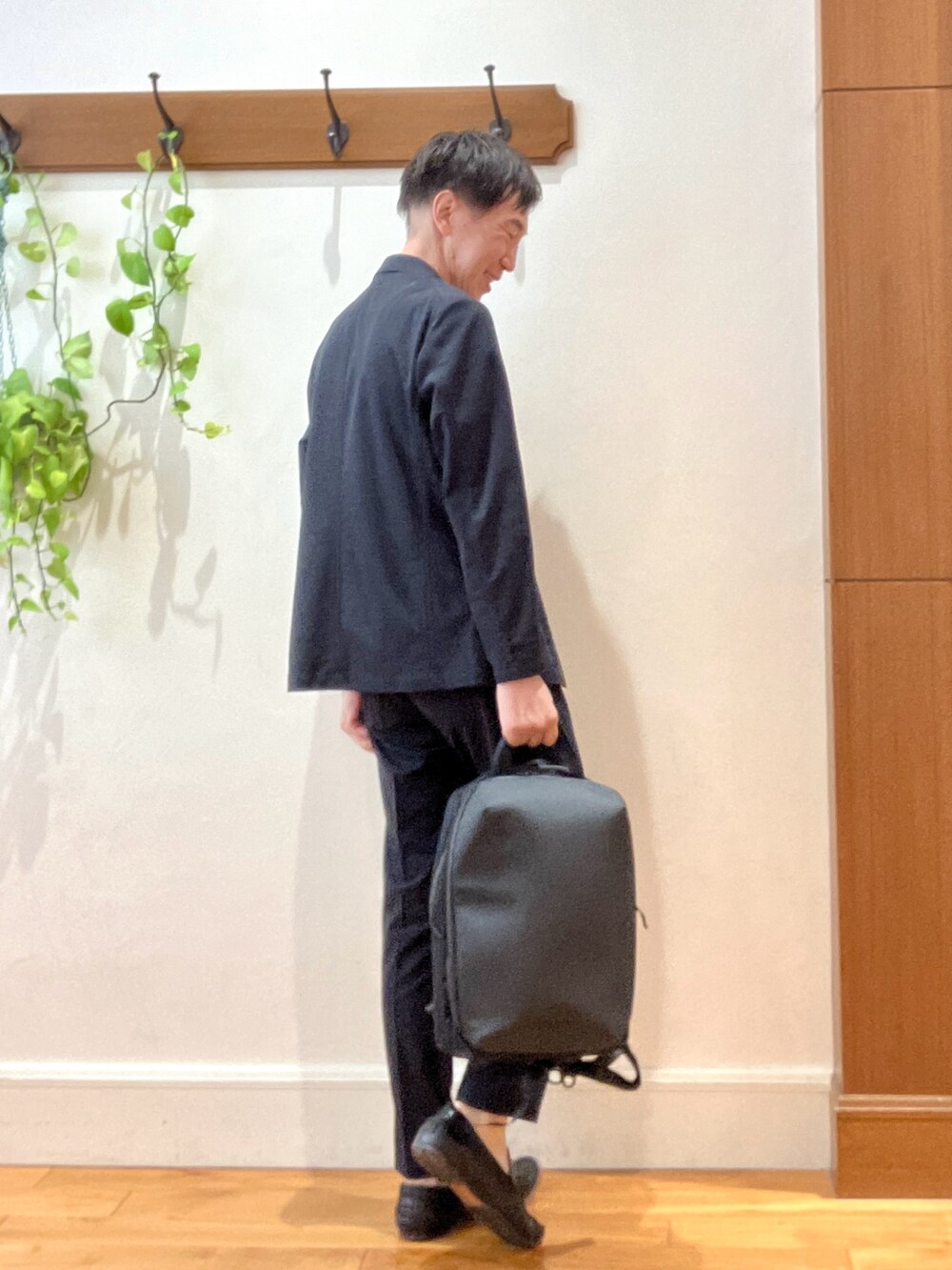 ブラック系のテーラードジャケット、ブラック系のその他パンツ、ブラック系のバックパック/リュックを着用したメンズの夏コーディネートの5枚目の写真
