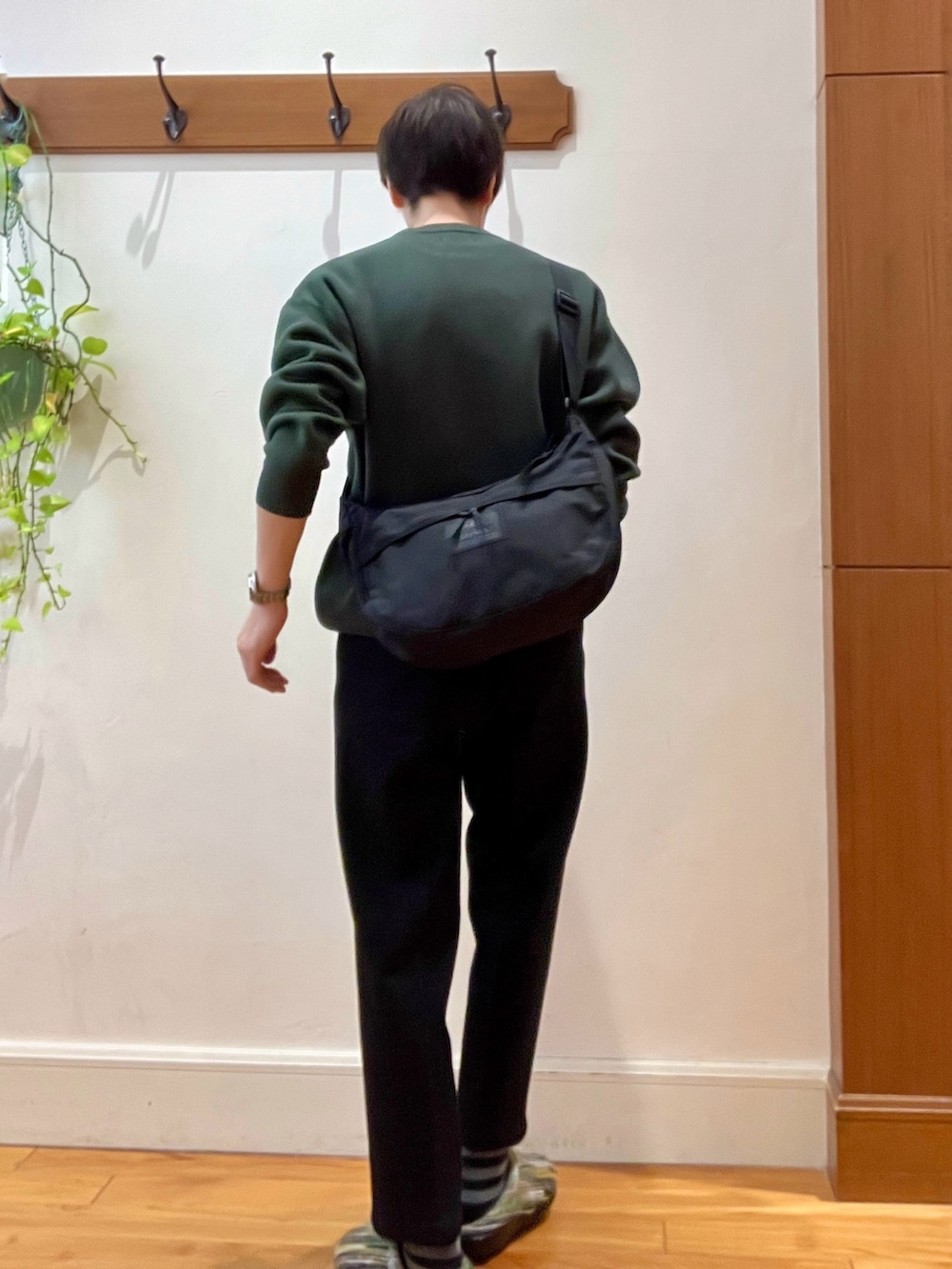 グリーン系のニット/セーター、ブラック系のショルダーバッグ、グリーン系のサンダルを着用したメンズの冬コーディネートの5枚目の写真