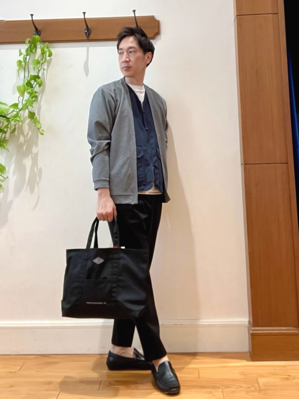 ブラック系のトートバッグ、ブラック系のその他パンツ、ホワイト系のTシャツ/カットソーを着用したメンズの春コーディネートの7枚目の写真