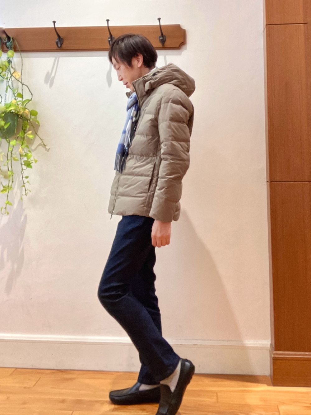 グリーン系のダウンジャケット/コート、ブルー系のニット/セーター、ブルー系のデニムパンツを着用したメンズの冬コーディネートの3枚目の写真