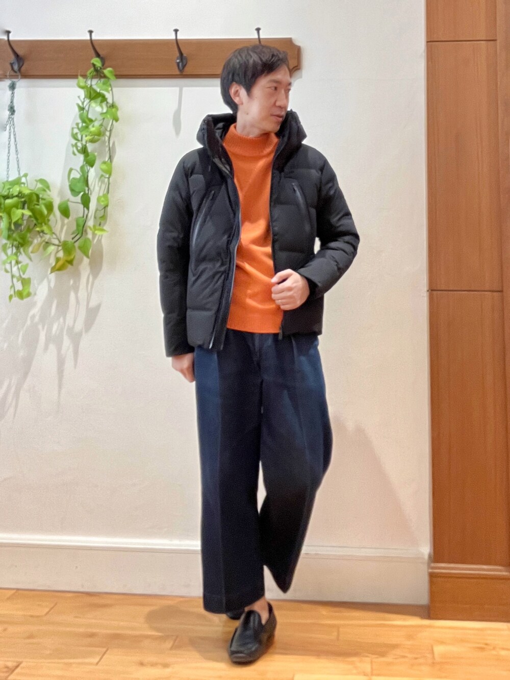 ブラック系のダウンジャケット/コート、オレンジ系のニット/セーターを着用したメンズの秋コーディネートの2枚目の写真