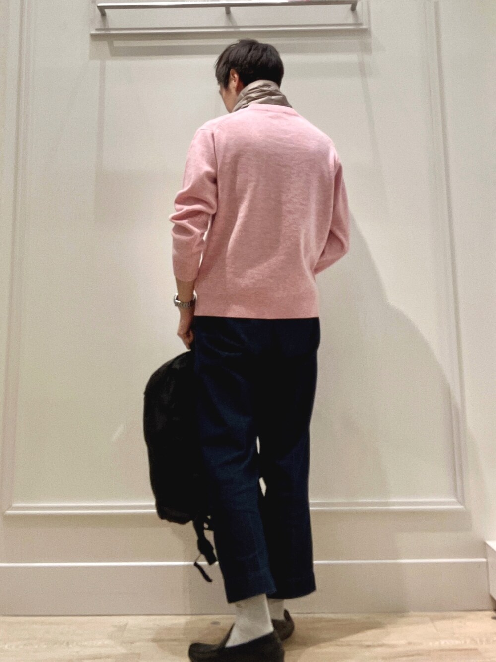 ピンク系のニット/セーター、ブラック系のバックパック/リュック、グリーン系のマフラーを着用したメンズの冬コーディネートの4枚目の写真