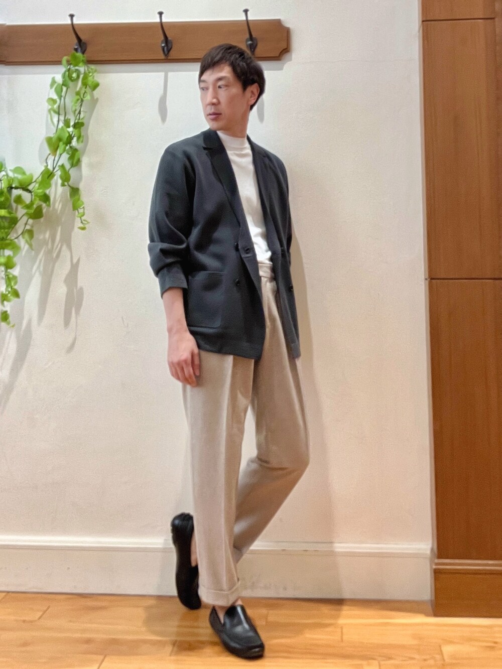 グリーン系のテーラードジャケット、ホワイト系のTシャツ/カットソー、ベージュ系のスラックスを着用したメンズの冬コーディネートの7枚目の写真