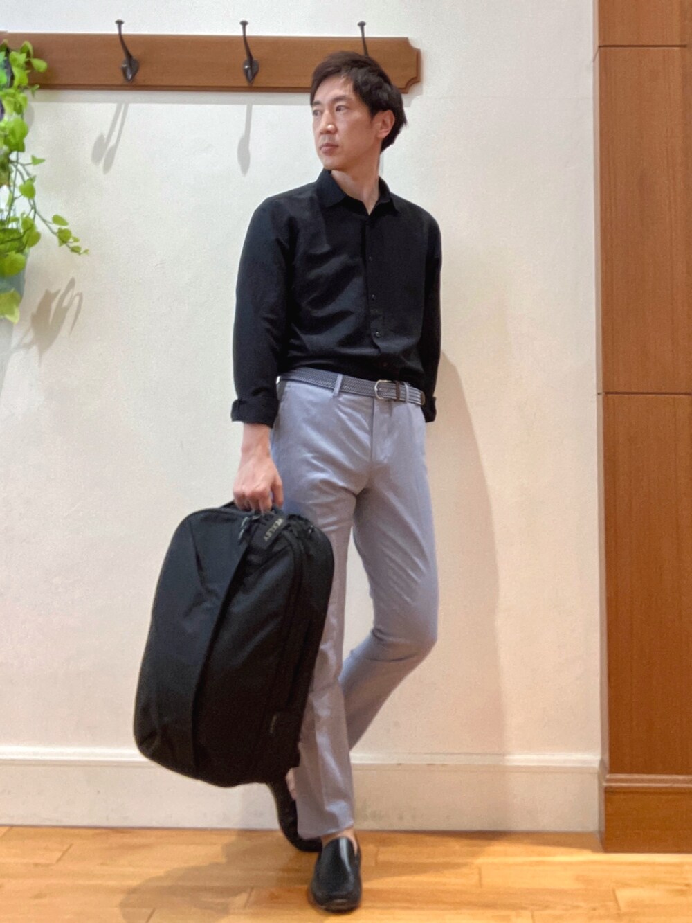 ブラック系のシャツ/ブラウス、ブルー系のチノパンツ、ブラック系のバックパック/リュックを着用したメンズの春コーディネートの7枚目の写真