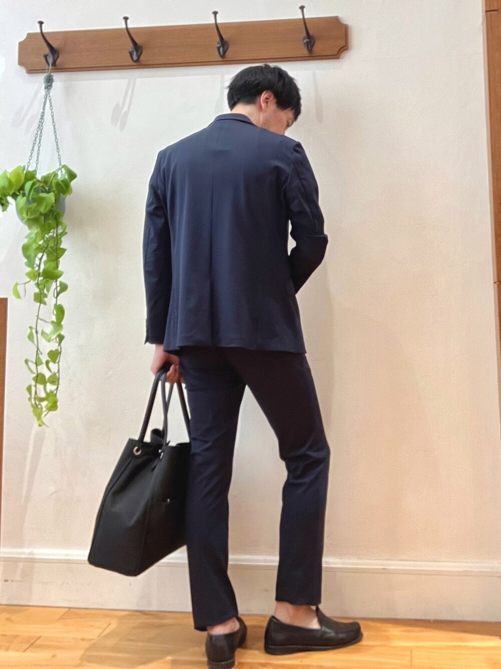 ブラック系のトートバッグ、ベージュ系のTシャツ/カットソー、ブルー系のテーラードジャケットを着用したメンズの春コーディネートの5枚目の写真