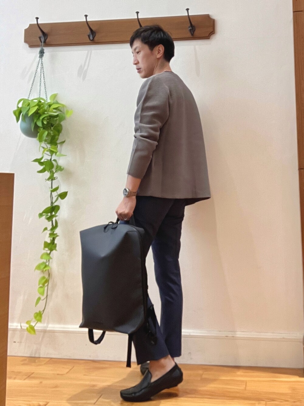 グリーン系のカーディガン/ボレロ、ブラック系のTシャツ/カットソー、ブルー系のバックパック/リュックを着用したメンズの秋コーディネートの3枚目の写真