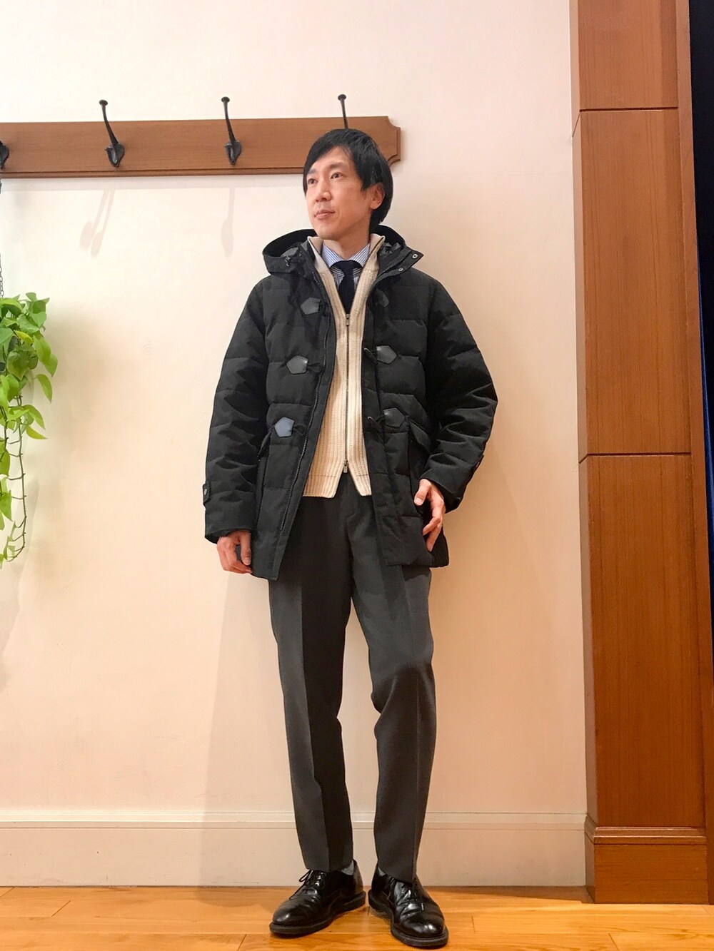 ブラック系のダウンジャケット/コート、ホワイト系のニット/セーターを着用したメンズの冬コーディネートの2枚目の写真