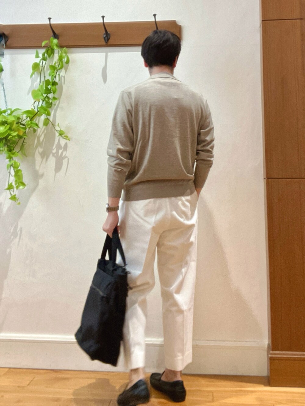 ホワイト系のデニムパンツ、ブラック系のトートバッグ、ベージュ系のニット/セーターを着用したメンズの冬コーディネートの5枚目の写真