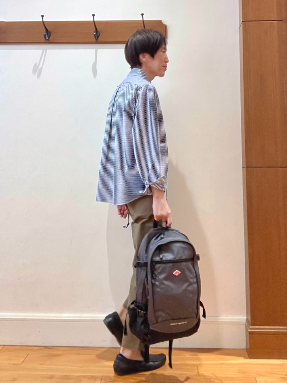 ブルー系のシャツ/ブラウス、グレー系のバックパック/リュック、グリーン系のチノパンツを着用したメンズの春コーディネートの5枚目の写真