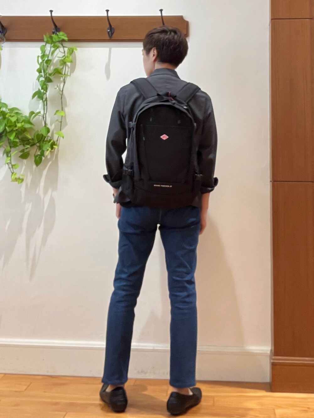 ブラック系のバックパック/リュック、ブルー系のデニムパンツ、ブラック系のTシャツ/カットソーを着用したメンズの夏コーディネートの5枚目の写真