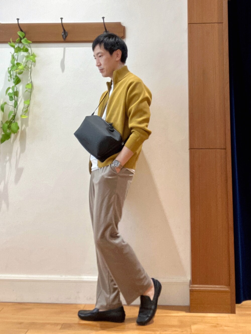 イエロー系のニット/セーター、ホワイト系のTシャツ/カットソー、ブラック系のショルダーバッグを着用したメンズの秋コーディネートの3枚目の写真