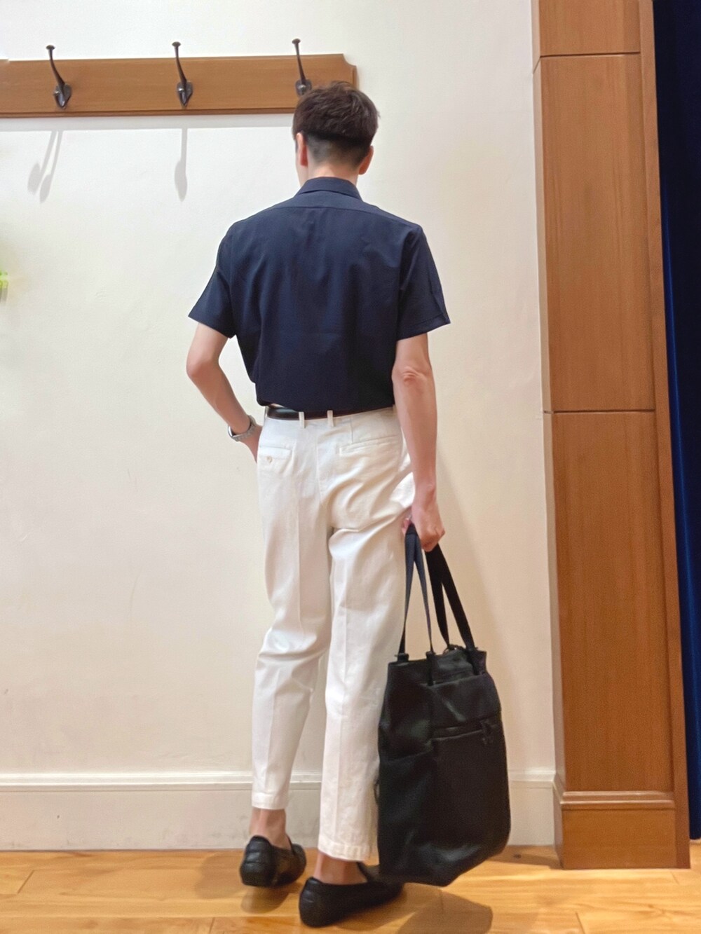 ホワイト系のデニムパンツ、ブルー系のビジネスシャツ、ブラック系のトートバッグを着用したメンズの夏コーディネートの4枚目の写真