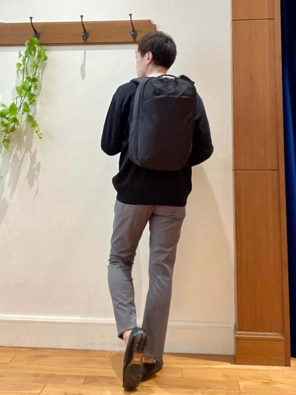ブラック系のカーディガン/ボレロ、ホワイト系のTシャツ/カットソー、ブラック系のバックパック/リュックを着用したメンズの冬コーディネートの5枚目の写真