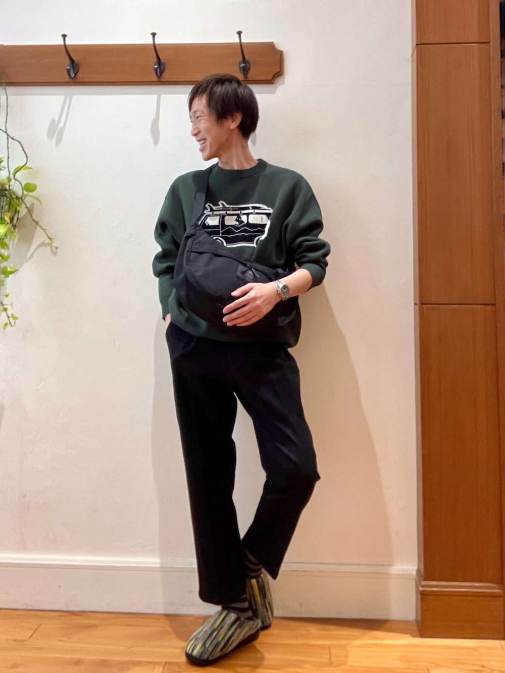 グリーン系のニット/セーター、ブラック系のショルダーバッグ、グリーン系のサンダルを着用したメンズの冬コーディネートの8枚目の写真