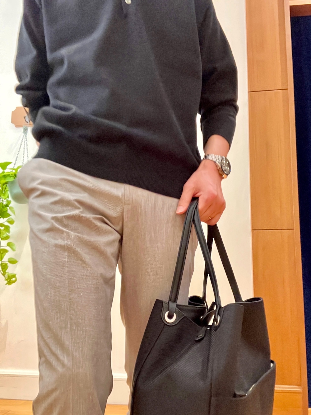 ブラック系のニット/セーター、ベージュ系のその他パンツ、ブラック系のトートバッグを着用したメンズの春コーディネートの8枚目の写真