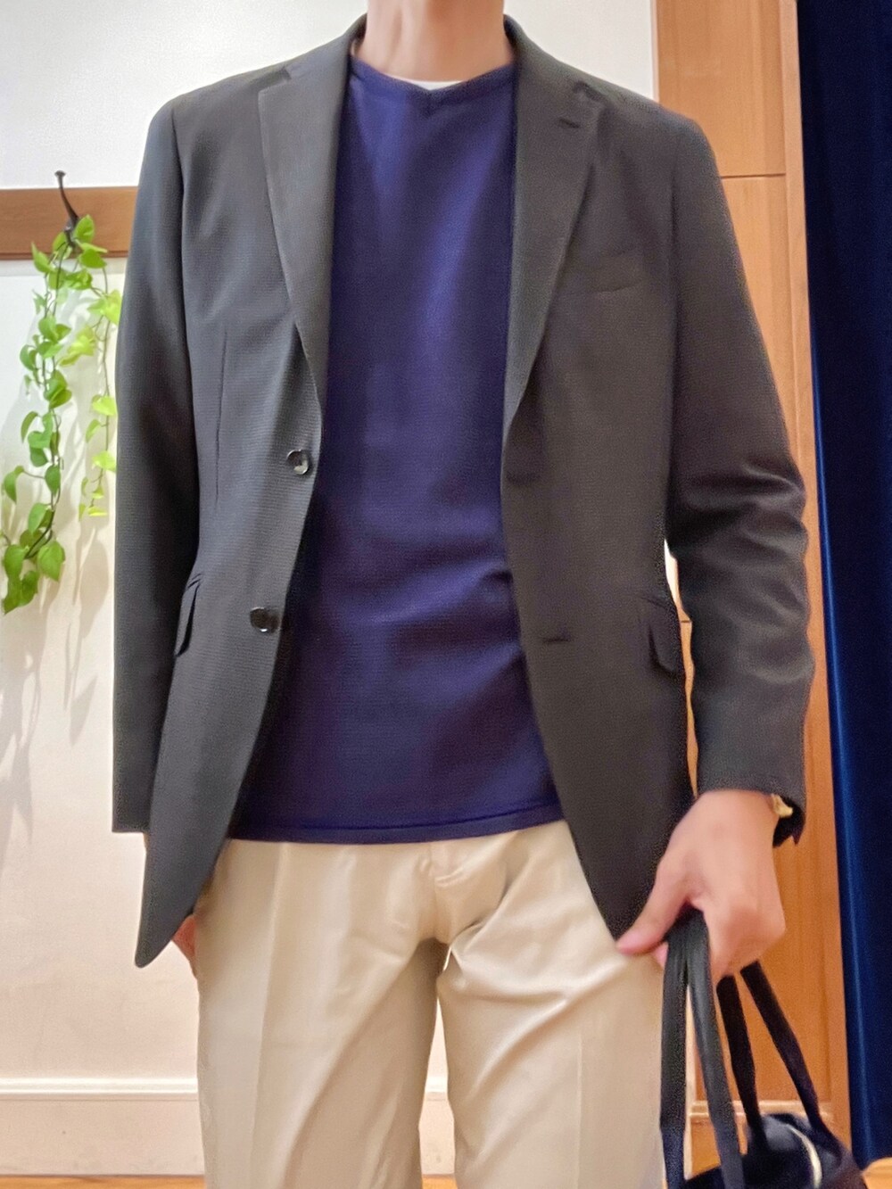 パープル系のニット/セーター、ホワイト系のチノパンツ、ブルー系のトートバッグを着用したメンズの秋コーディネートの8枚目の写真