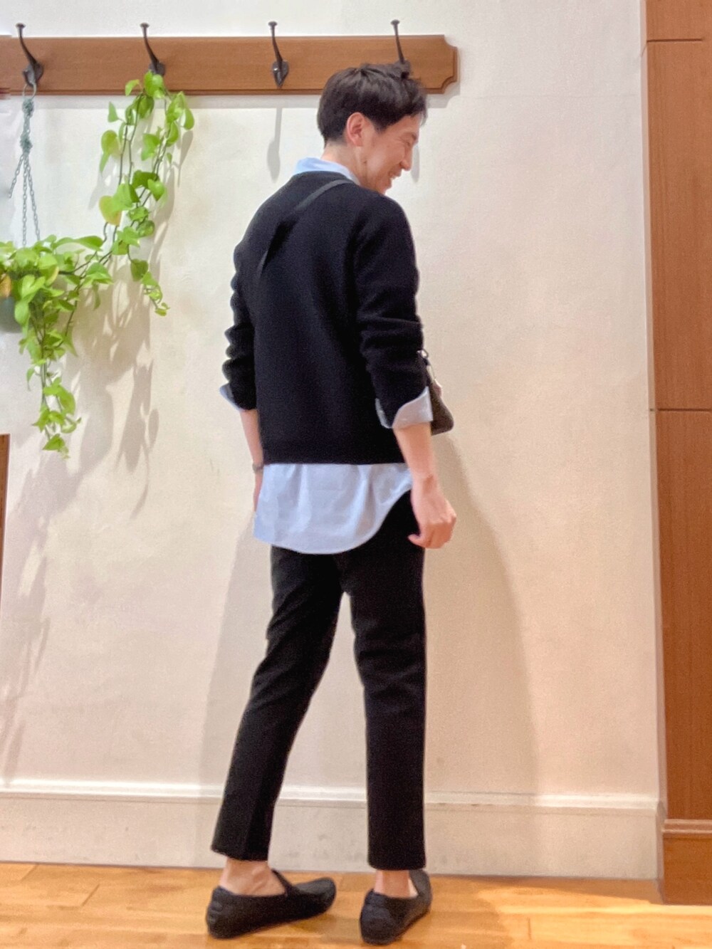 ブラック系のニット/セーター、グレー系のショルダーバッグ、ブルー系のシャツ/ブラウスを着用したメンズの春コーディネートの6枚目の写真