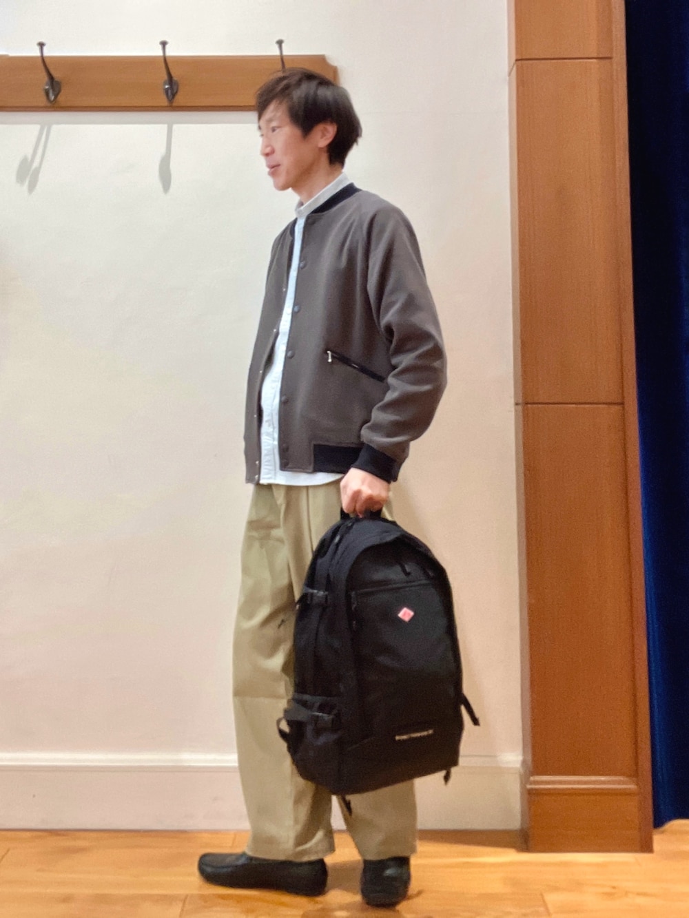 グレー系のブルゾン、グリーン系のシャツ/ブラウス、ブラック系のバックパック/リュックを着用したメンズの冬コーディネートの2枚目の写真