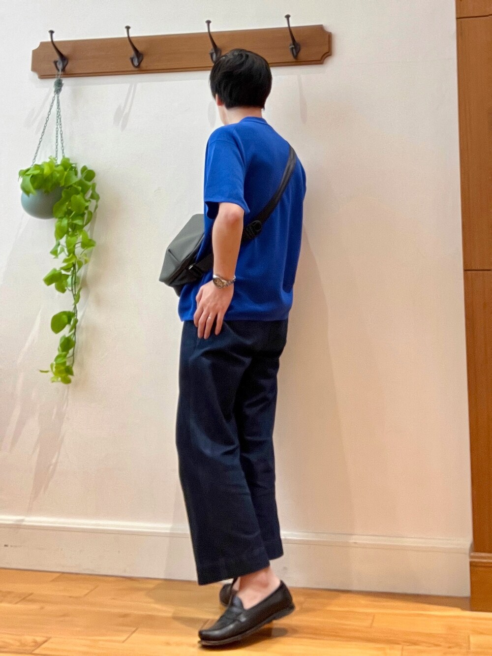 グリーン系のショルダーバッグ、ブルー系のポロシャツを着用したメンズの春コーディネートの3枚目の写真